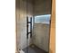 Modern walk-in shower featuring sleek tile, a glass door and a built-in niche for storage at 7661 Carriage House Way, Zionsville, IN 46077