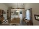 Bright dining room with a long wooden table, a view into the kitchen, and natural light from the window at 7733 Sergi Canyon Dr, Indianapolis, IN 46217