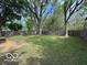 Spacious fenced backyard featuring mature trees and a well-maintained lawn at 7842 Brennan Rd, Indianapolis, IN 46219