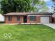 Charming brick home with an attached garage and a well-manicured front lawn at 7842 Brennan Rd, Indianapolis, IN 46219