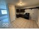 Functional kitchen with essential appliances, sleek dark cabinets, and tiled floors at 7842 Brennan Rd, Indianapolis, IN 46219