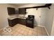 Traditional kitchen showcasing brown cabinets, laminate countertops, and neutral tiled floor at 7842 Brennan Rd, Indianapolis, IN 46219