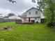 Spacious backyard featuring a red deck perfect for outdoor entertaining on a large lawn and tall trees at 8030 Winchester Pl, Indianapolis, IN 46227