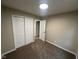 Bedroom with neutral carpeting features a closet with sliding doors and a doorway that opens to another room at 8030 Winchester Pl, Indianapolis, IN 46227