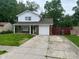 Charming two-story home with a well-maintained lawn and a driveway leading to an attached garage at 8030 Winchester Pl, Indianapolis, IN 46227