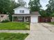 Inviting two-story home with a well-manicured lawn, covered entryway, and attached single car garage at 8030 Winchester Pl, Indianapolis, IN 46227