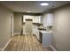 Modern kitchen with new white cabinetry, stainless steel sink, new vinyl floors, and neutral color scheme at 8030 Winchester Pl, Indianapolis, IN 46227