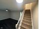 View of living room, and staircase with carpet runner and white banister and dark flooring in the living area at 8030 Winchester Pl, Indianapolis, IN 46227