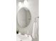 Clean bathroom with a round mirror, modern fixtures, and a soft white towel at 8266 Glacier Ridge Dr, Fishers, IN 46038