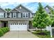 Charming townhome featuring a two-car garage, gray siding, and lush landscaping in a suburban setting at 8266 Glacier Ridge Dr, Fishers, IN 46038