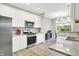 Modern kitchen with stainless steel appliances, white cabinets, and a view to the dining area at 8266 Glacier Ridge Dr, Fishers, IN 46038