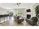 Comfortable living room with a fireplace, ceiling fan, and open layout to the dining area at 8266 Glacier Ridge Dr, Fishers, IN 46038