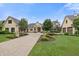 Stunning home featuring a manicured lawn, brick driveway, and charming architectural details under a clear blue sky at 860 Chatham Hills Blvd, Westfield, IN 46074