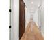 Hallway featuring hardwood floors, modern lighting, and a striking barn door, leading to various rooms at 860 Chatham Hills Blvd, Westfield, IN 46074