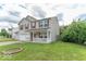 This delightful two-story house has an attached garage and a cozy covered porch at 8712 Mellot Way, Camby, IN 46113