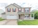 Charming two-story home featuring a covered front porch, red shutters, and a well-maintained lawn at 8712 Mellot Way, Camby, IN 46113