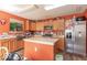 Bright kitchen featuring wooden cabinets, stainless steel appliances, and an island with a light countertop at 8712 Mellot Way, Camby, IN 46113