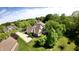 Stunning aerial view of a home with mature trees, lush green lawns and long driveway at 897 Copperwood Dr, Carmel, IN 46033