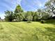 Well-manicured lawn, mature trees, and lush green landscape in this large backyard at 897 Copperwood Dr, Carmel, IN 46033