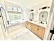 Bright bathroom featuring double vanity, bathtub and a large window at 897 Copperwood Dr, Carmel, IN 46033