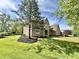 Classic brick home with a well-manicured lawn and mature trees provides a picturesque and welcoming curb appeal at 897 Copperwood Dr, Carmel, IN 46033