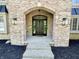Arched entryway of a brick home with decorative sconces and a welcoming front door enhances the curb appeal at 897 Copperwood Dr, Carmel, IN 46033