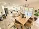 Bright open kitchen with white cabinets, large island, wood floors, and a dining area by a sliding glass door at 897 Copperwood Dr, Carmel, IN 46033