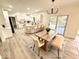 Bright open kitchen with white cabinets, large island, wood floors, and a dining area by a sliding glass door at 897 Copperwood Dr, Carmel, IN 46033