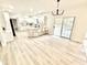 Open concept kitchen and living area with wood floors, white cabinets and a modern light fixture at 897 Copperwood Dr, Carmel, IN 46033