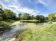 Scenic pond surrounded by lush greenery, enhancing the tranquility of the property at 897 Copperwood Dr, Carmel, IN 46033