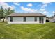 A view of the back of the home with sliding doors and a large green lawn, ideal for outdoor activities at 905 Congressional Way, Shelbyville, IN 46176