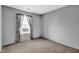 Bright, carpeted bedroom featuring a large window with white blinds and grey walls at 905 Congressional Way, Shelbyville, IN 46176