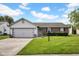 Charming single-story home featuring a brick facade, attached garage, and well-maintained lawn at 905 Congressional Way, Shelbyville, IN 46176