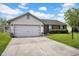 Attractive ranch home with brick accents, shutters, and a wide driveway leading to a two-car garage at 905 Congressional Way, Shelbyville, IN 46176