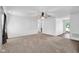 Bright living room featuring carpeted floors and an overhead ceiling fan with a view to the front entry at 905 Congressional Way, Shelbyville, IN 46176