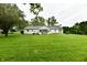 Expansive backyard with lush green lawn, mature trees, and a detached garage at 9098 W 1050 N, Elwood, IN 46036