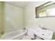 Bathroom featuring a standard tub, toilet, and sink with a mirror above, offering essential functionality at 9098 W 1050 N, Elwood, IN 46036