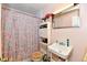 Small bathroom features a patterned shower curtain, pink walls, and functional fixtures at 9098 W 1050 N, Elwood, IN 46036