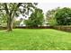Expansive green backyard with a mature tree and wooden fence, offering privacy and space at 924 S B St, Elwood, IN 46036