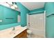 Modern bathroom featuring turquoise walls, wooden vanity and a shower tub with a white surround at 924 S B St, Elwood, IN 46036