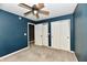 This bedroom features a ceiling fan, two closets and is painted in a striking blue tone at 924 S B St, Elwood, IN 46036