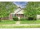 Charming brick home featuring a well-maintained front yard with mature trees and lush landscaping at 924 S B St, Elwood, IN 46036