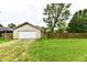 Spacious two-car garage with a driveway, complemented by a grassy backyard and wooden fence at 924 S B St, Elwood, IN 46036