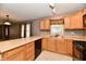 Efficient kitchen boasts light wood cabinets, black dishwasher, and a view of the connected living space at 924 S B St, Elwood, IN 46036