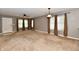 Bright living room with neutral paint, plush carpet, large windows, and modern ceiling fan at 924 S B St, Elwood, IN 46036