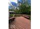 View of the spacious, stained back deck with built-in benches and a wooded backyard at 9650 Copley Dr, Carmel, IN 46290