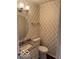 Charming powder room features decorative wallpaper, granite counters, and updated lighting at 9650 Copley Dr, Carmel, IN 46290