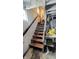 Basement stairs with wooden handrail leading to unfinished basement with concrete walls at 100 N 6Th Ave, Beech Grove, IN 46107