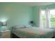 Bright bedroom featuring a large window, light green walls, and a cozy floral-patterned bedspread at 1029 Bridgeport Dr, Westfield, IN 46074