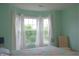 Light-filled bedroom showcasing a bay window with white curtains and vibrant floral bedding at 1029 Bridgeport Dr, Westfield, IN 46074